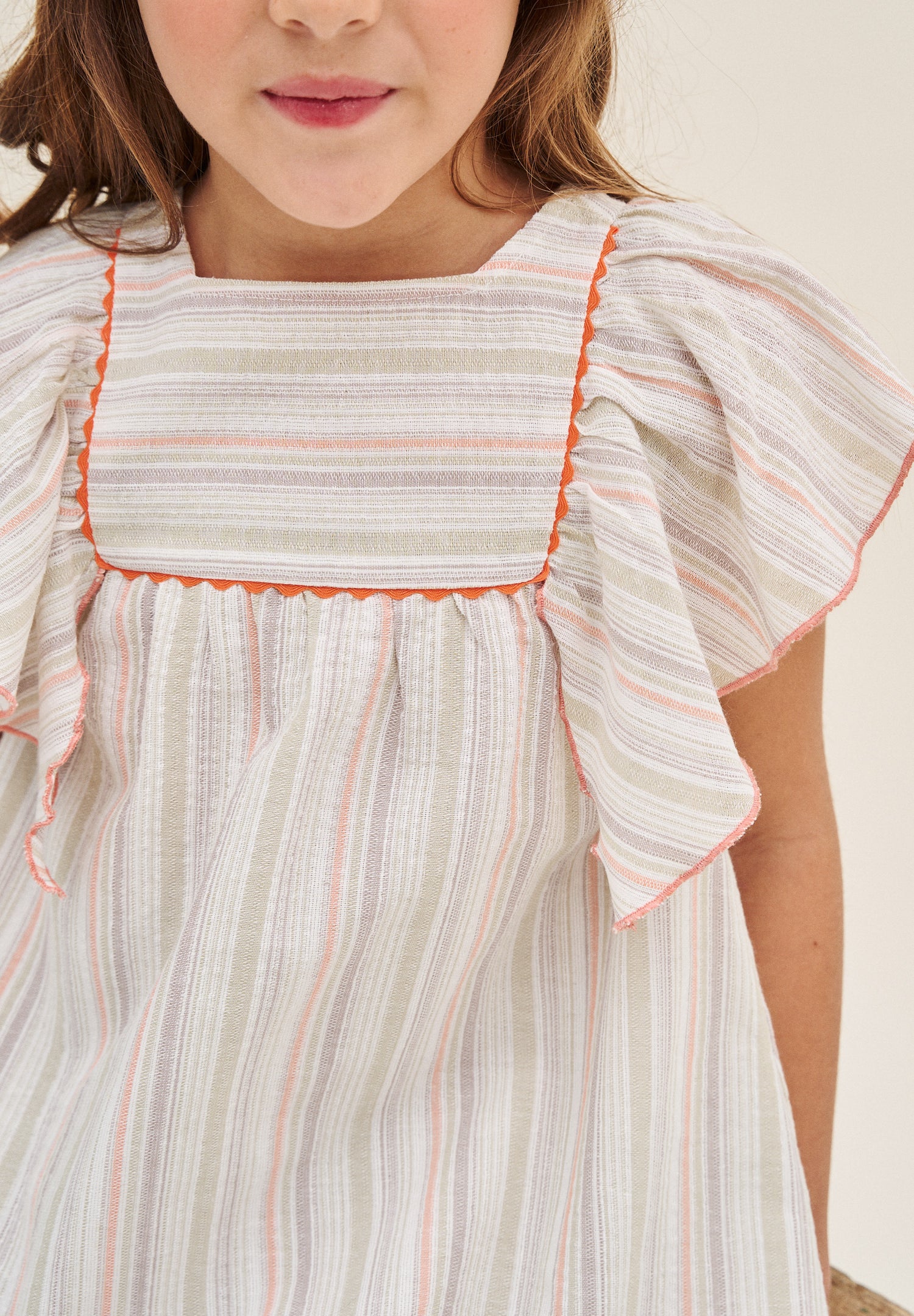 Vestido niña de rayas naranja, gris y verde, con manga volante y pechera cuadrada borde naranja