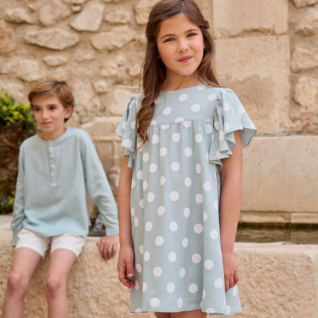 Vestido de niña azul cielo con lunares blancos y lazo en espalda