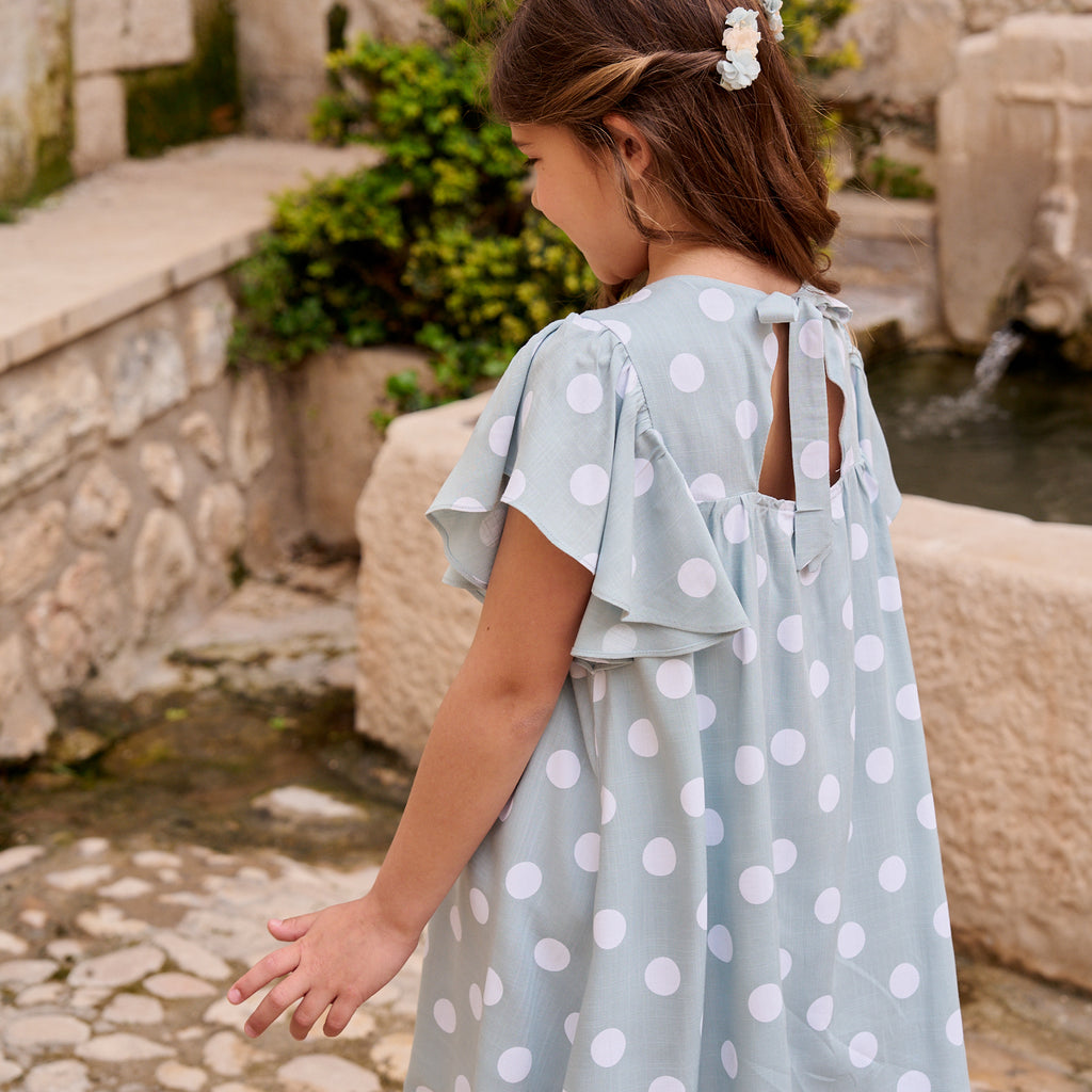 Vestido de niña azul cielo con lunares blancos y lazo en espalda