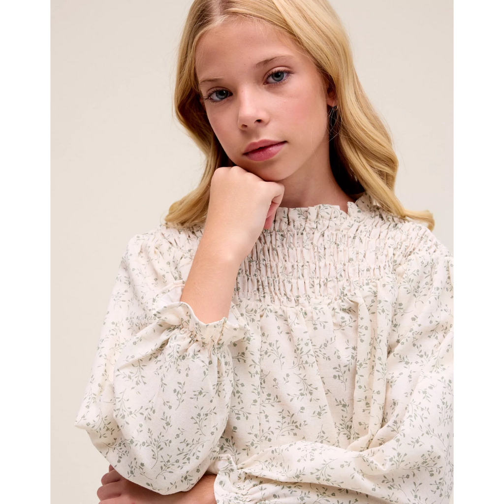 Blusa de niña color crudo con estampado floral verde
