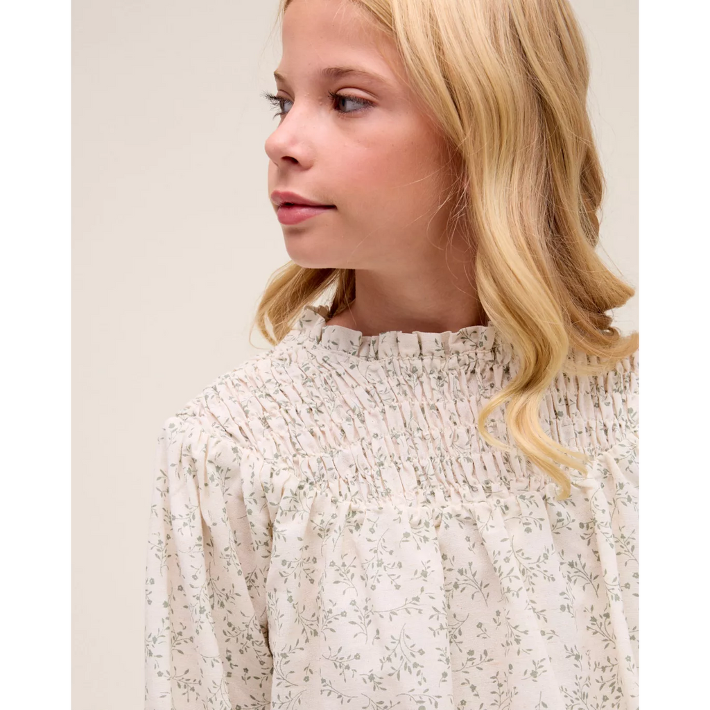 Blusa de niña color crudo con estampado floral verde