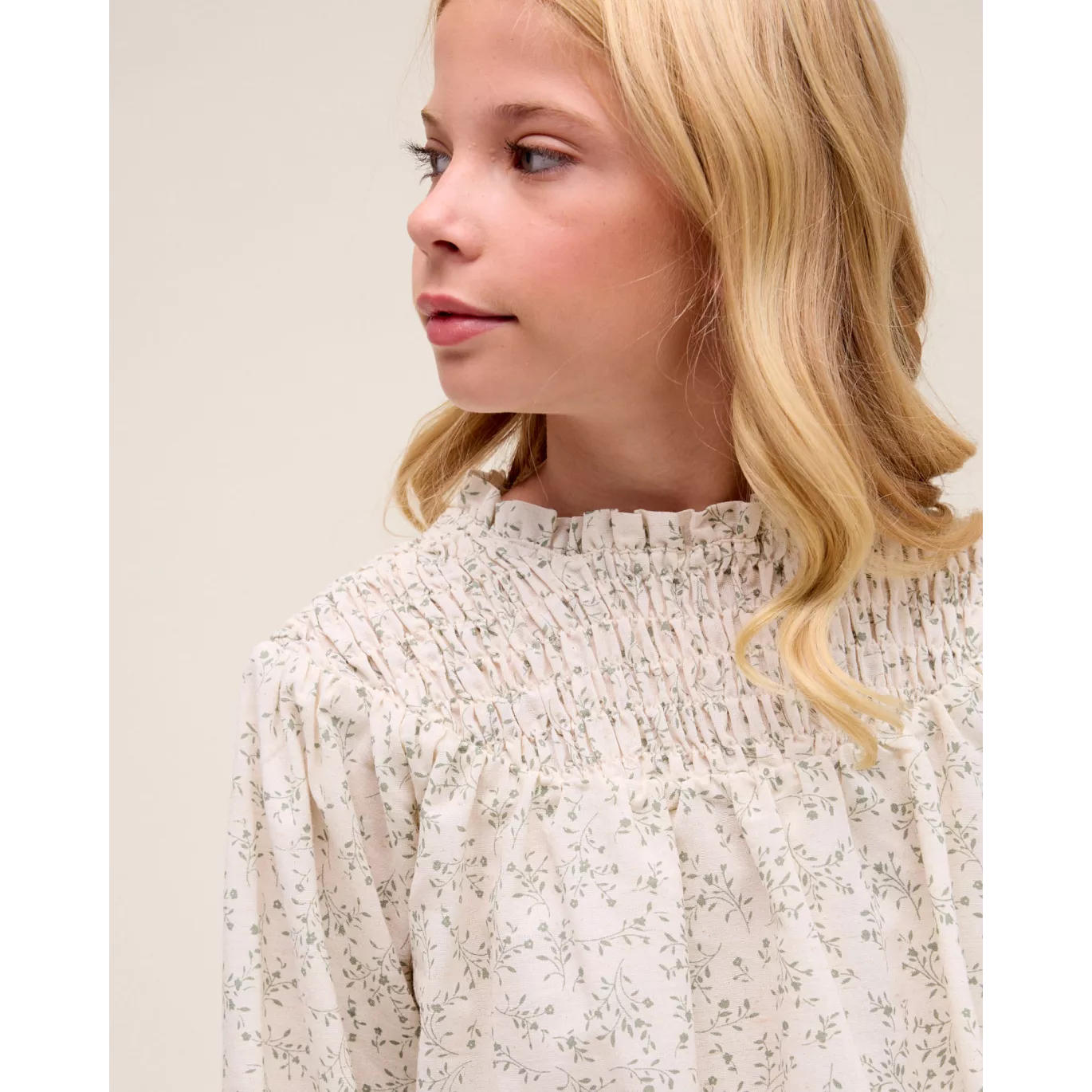 Blusa de niña color crudo con estampado floral verde