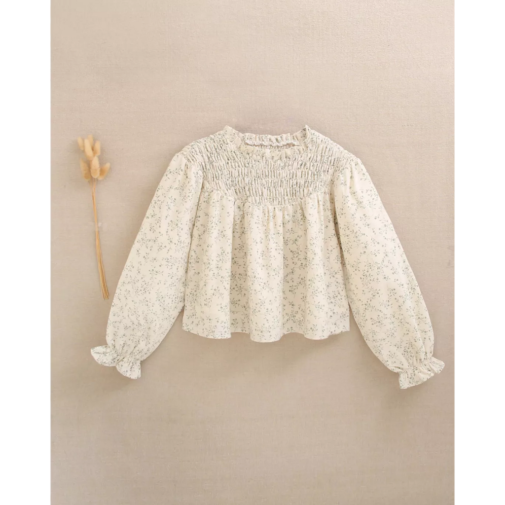 Blusa de niña color crudo con estampado floral verde