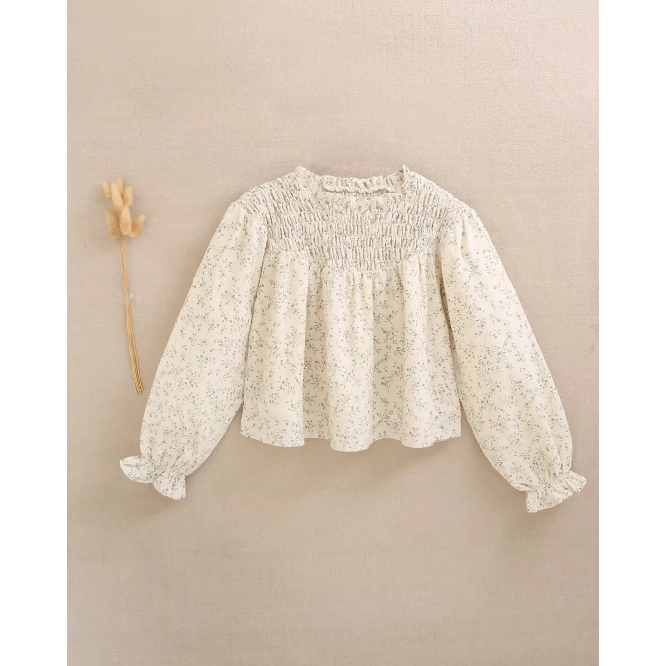 Blusa de niña color crudo con estampado floral verde