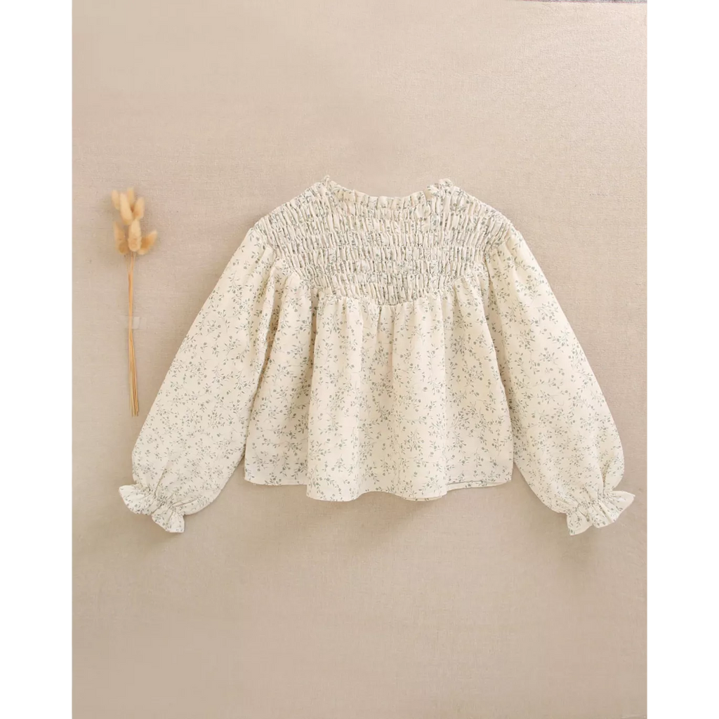Blusa de niña color crudo con estampado floral verde