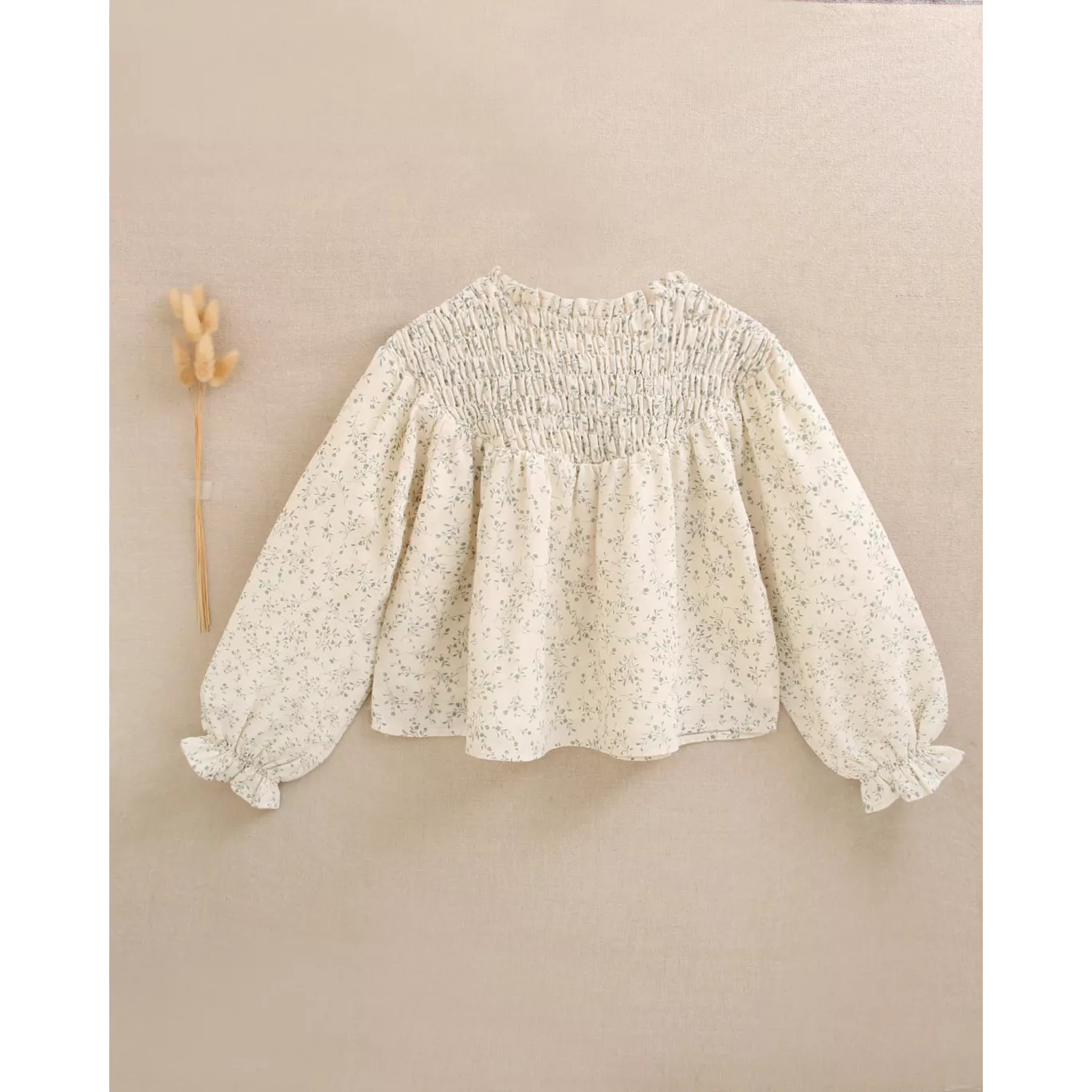 Blusa de niña color crudo con estampado floral verde