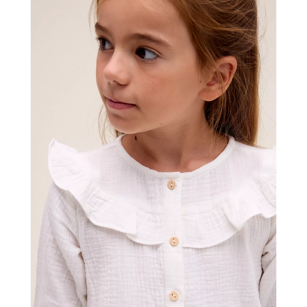 Blusa manga larga de niña en blanco con volante