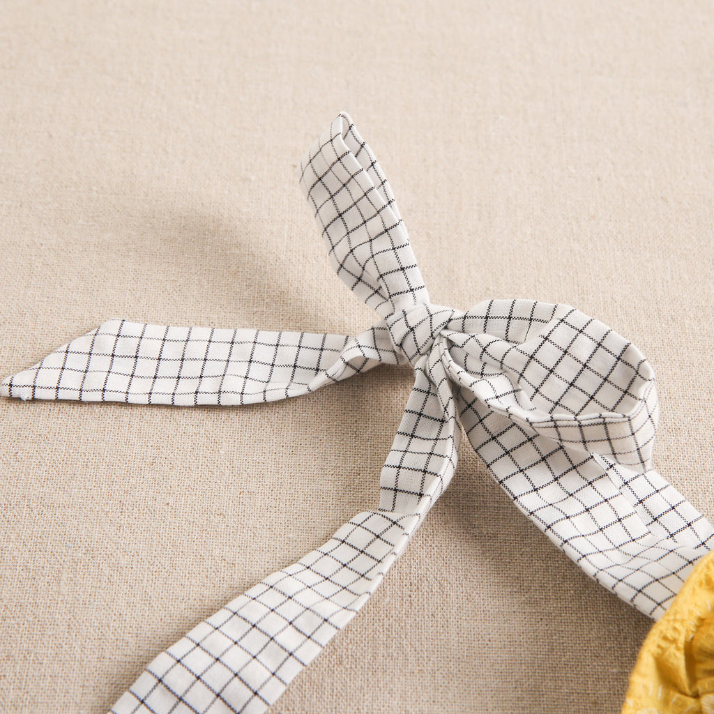 Vestido de niña amarillo mostaza con estampado de soles