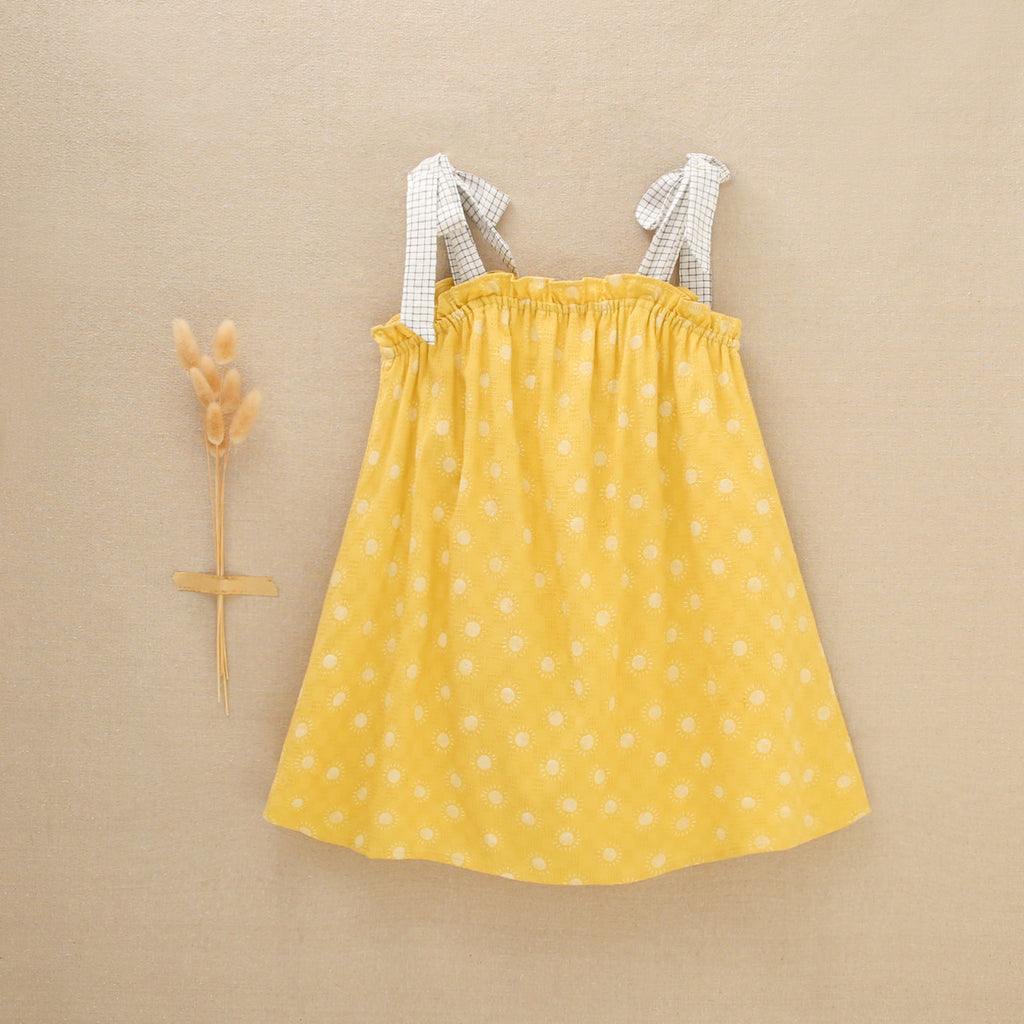Vestido de niña amarillo mostaza con estampado de soles