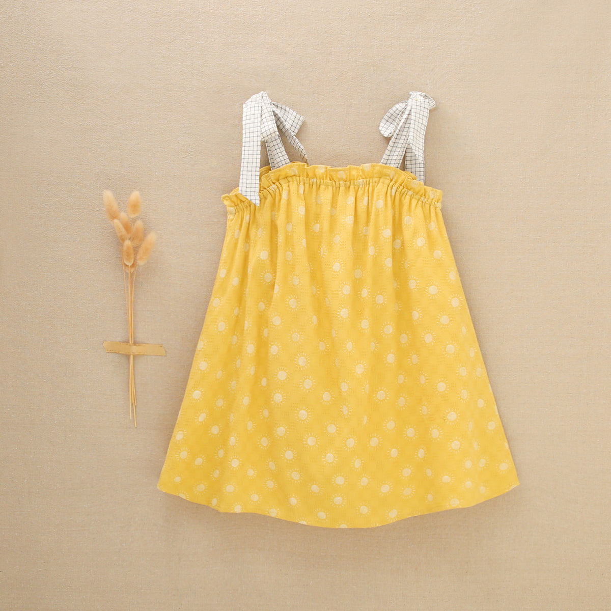 Vestido de niña amarillo mostaza con estampado de soles