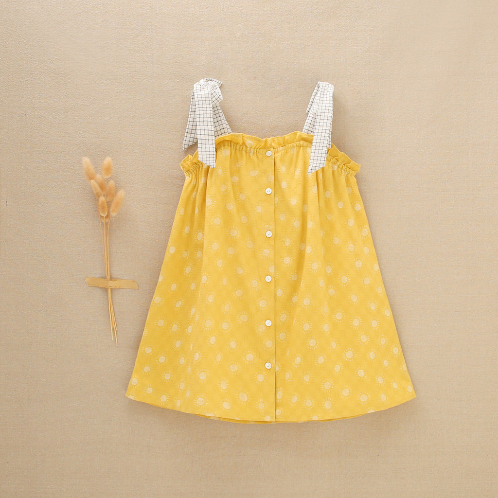 Vestido de niña amarillo mostaza con estampado de soles