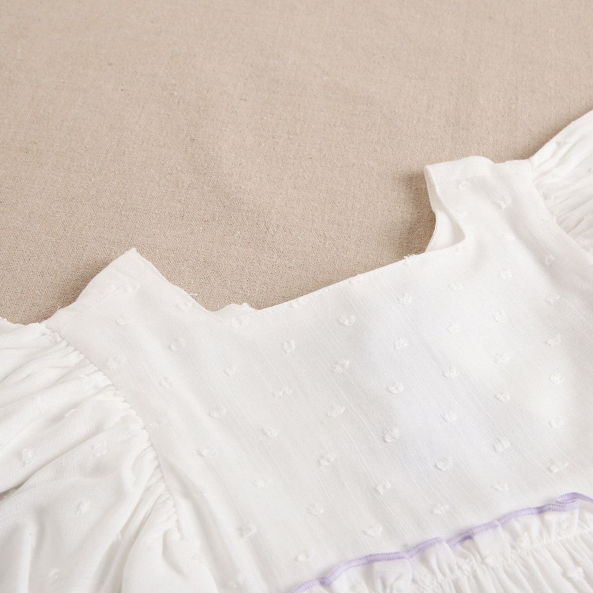 Vestido de niña blanco con ribetes lilas