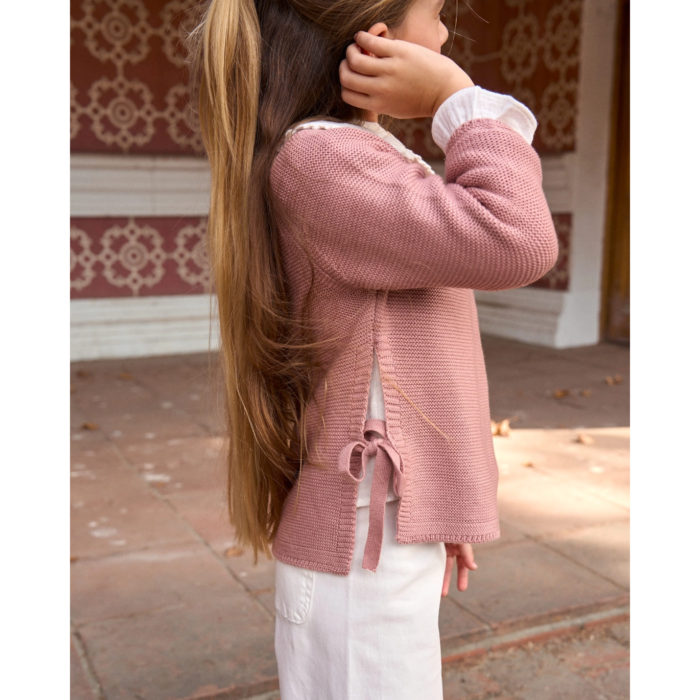 Jersey de niña de punto en rosa con lazos laterales