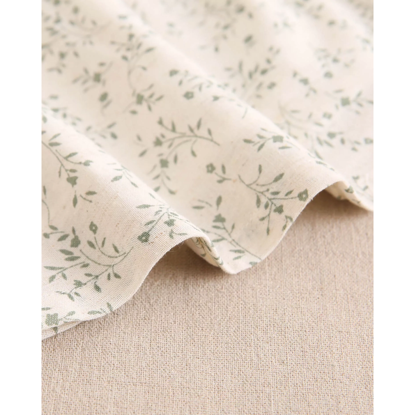 Vestido de bebé color crudo con estampado floral verde y volante en el cuello